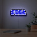 Sega LED lightbox hanging on a room wall with soft blue light