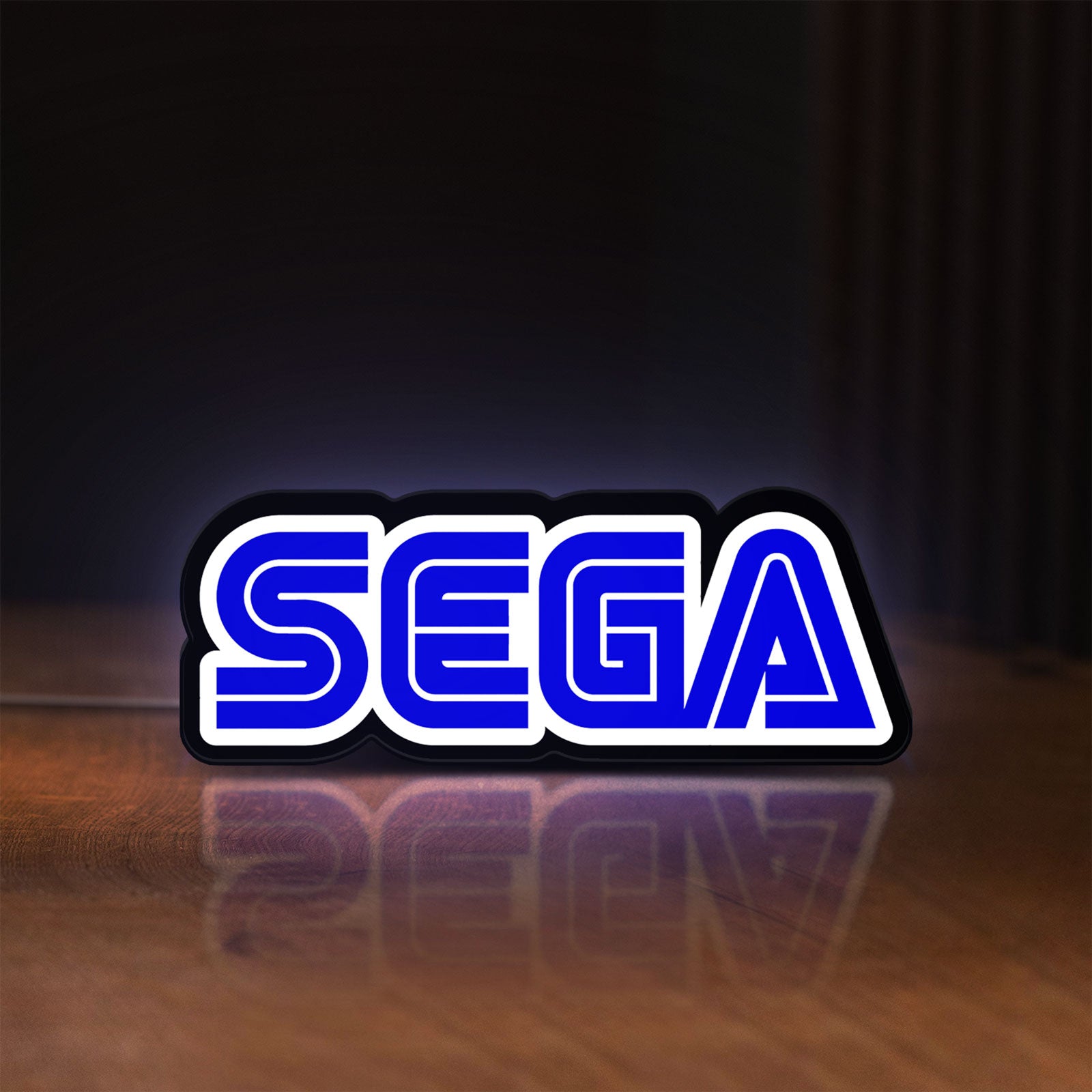 Front view of Sega LED lightbox sign glowing on a wooden desk