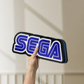 Unlit Sega LED lightbox held by hand to show size and details
