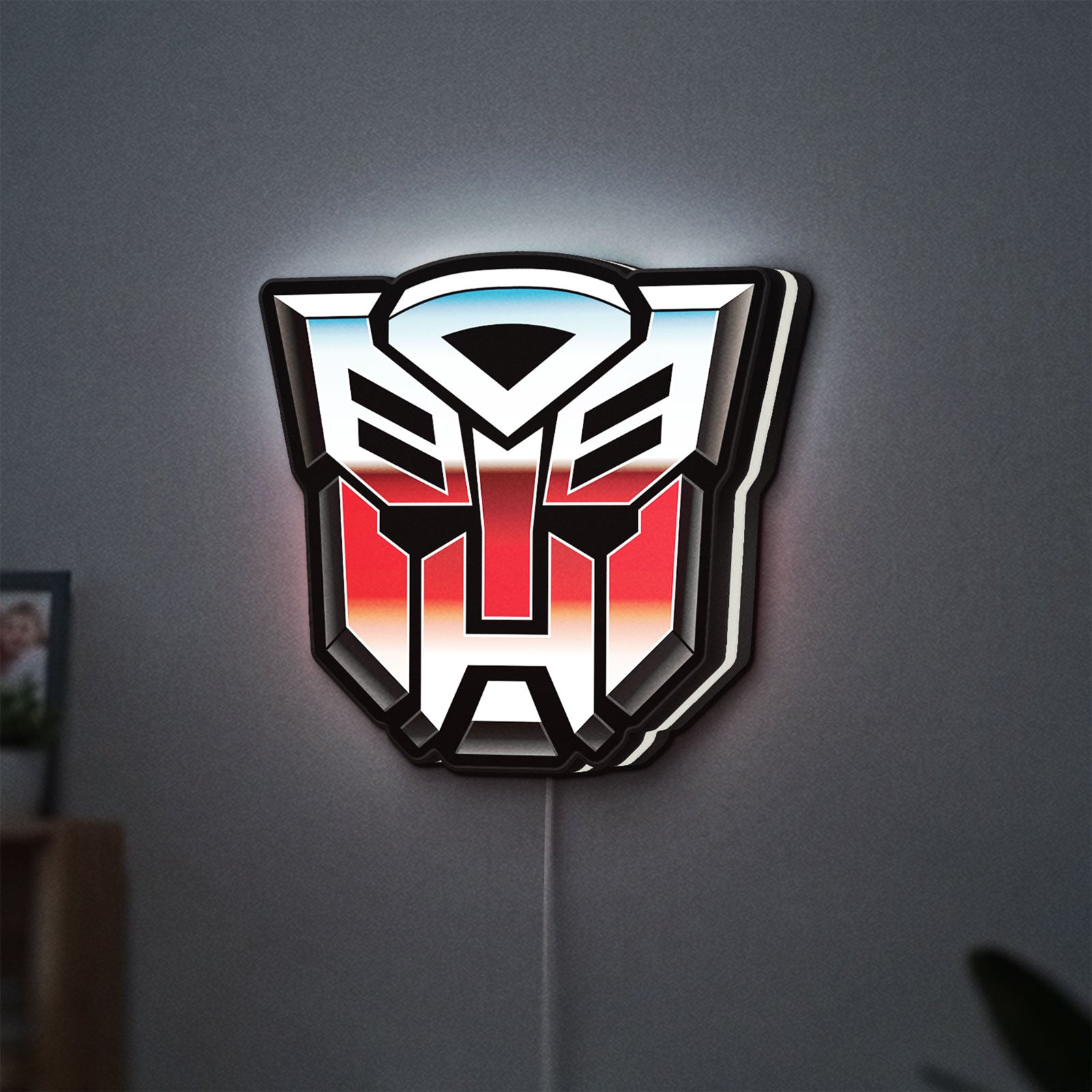 Transformers Autobots LED lightbox hanging on a wall with white glow