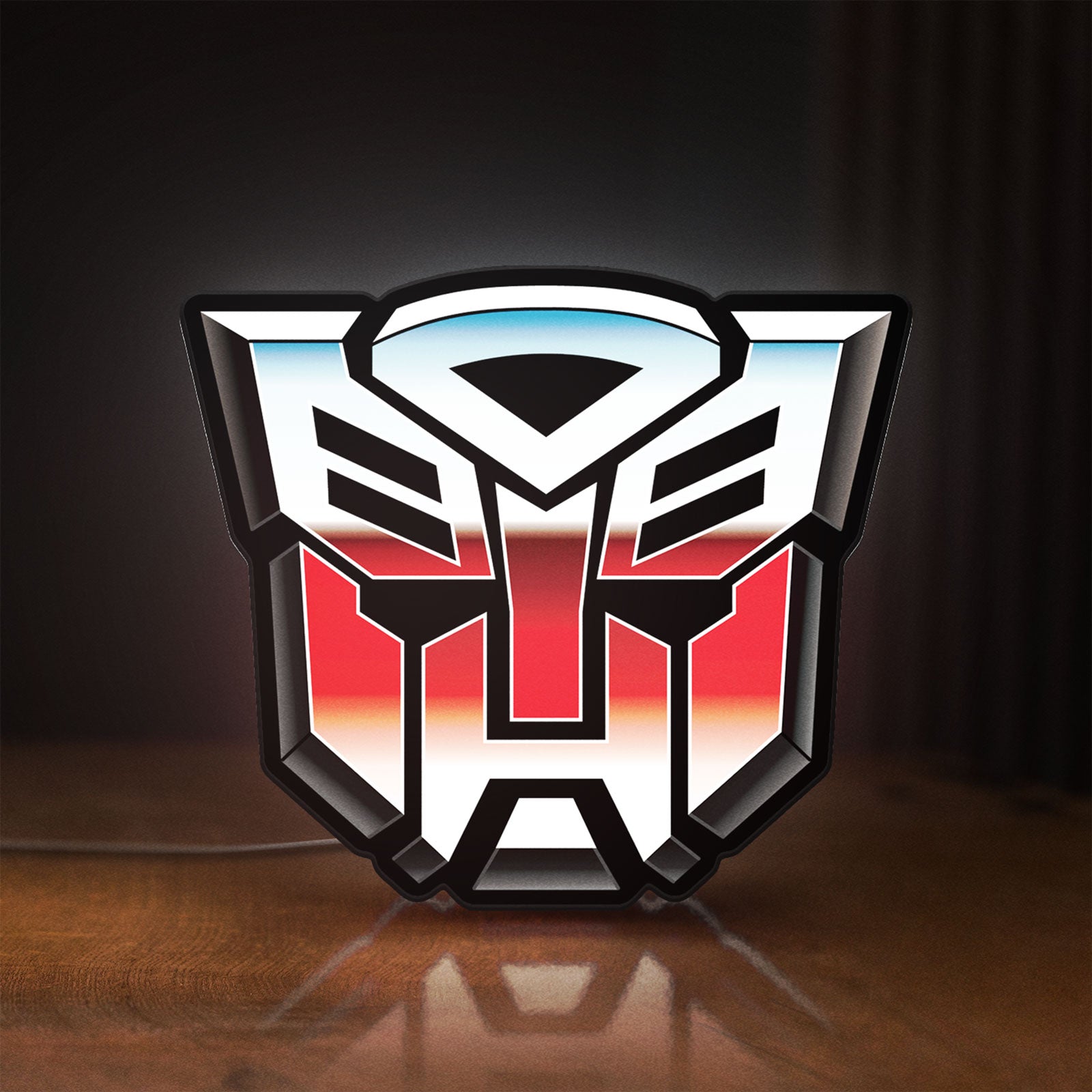 Front view of Transformers Autobots LED lightbox sign glowing on a wooden desk