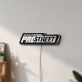 Unlit Need for Speed Prostreet Sign LED lightbox mounted on a wall in daylight