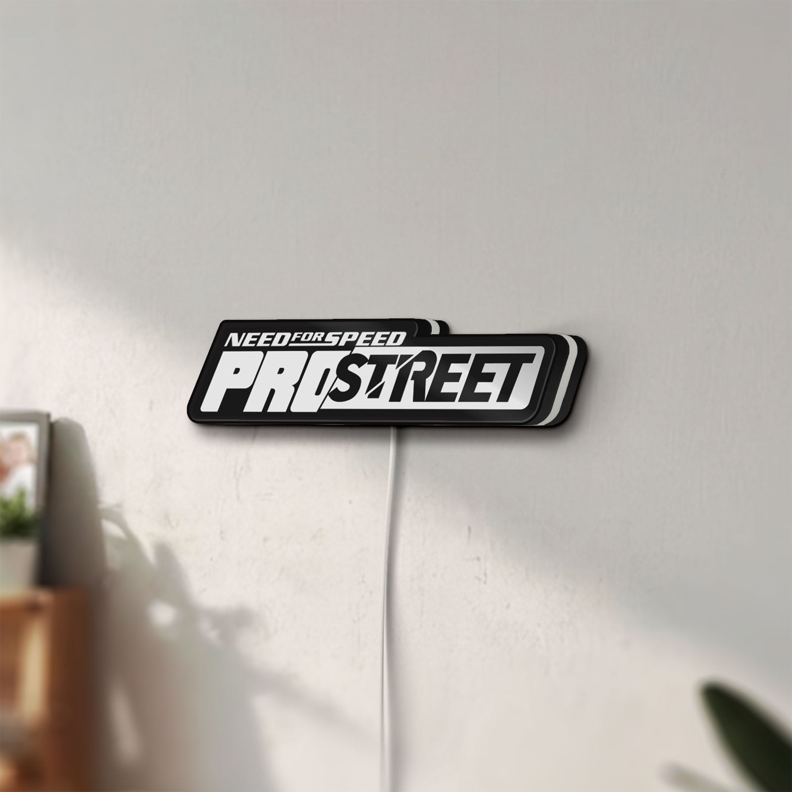 Unlit Need for Speed Prostreet Sign LED lightbox mounted on a wall in daylight