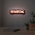Roblox LED lightbox hanging on a room wall with soft red light