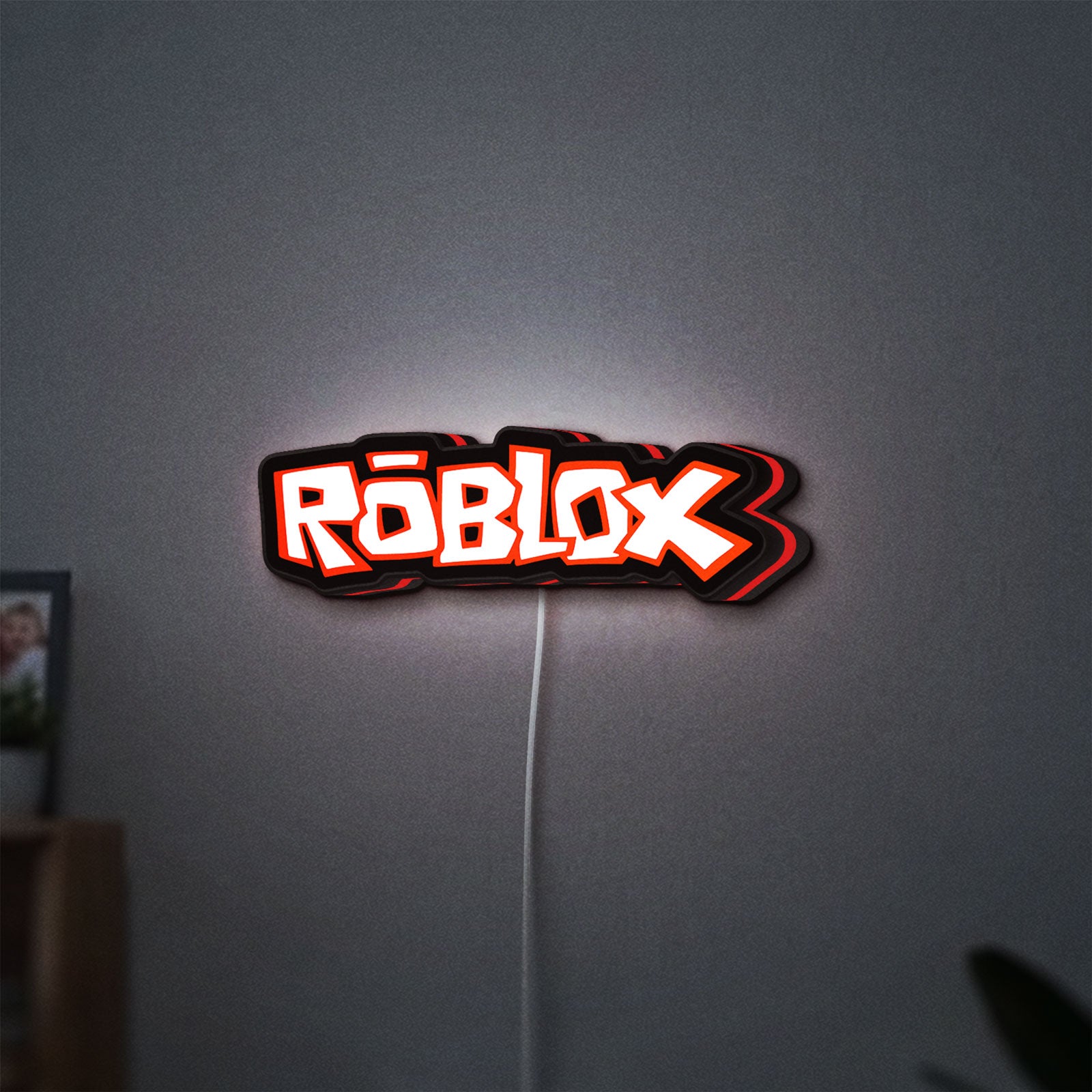 Roblox LED lightbox hanging on a wall with red glow