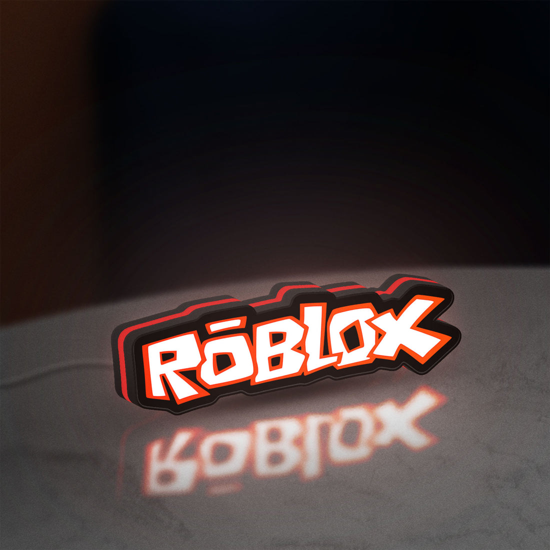Roblox LED lightbox hanging on a wall with red glow