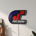 Unlit Gran Turismo LED lightbox mounted on a wall in daylight