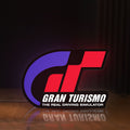 Front view of Gran Turismo LED lightbox sign glowing on a wooden desk