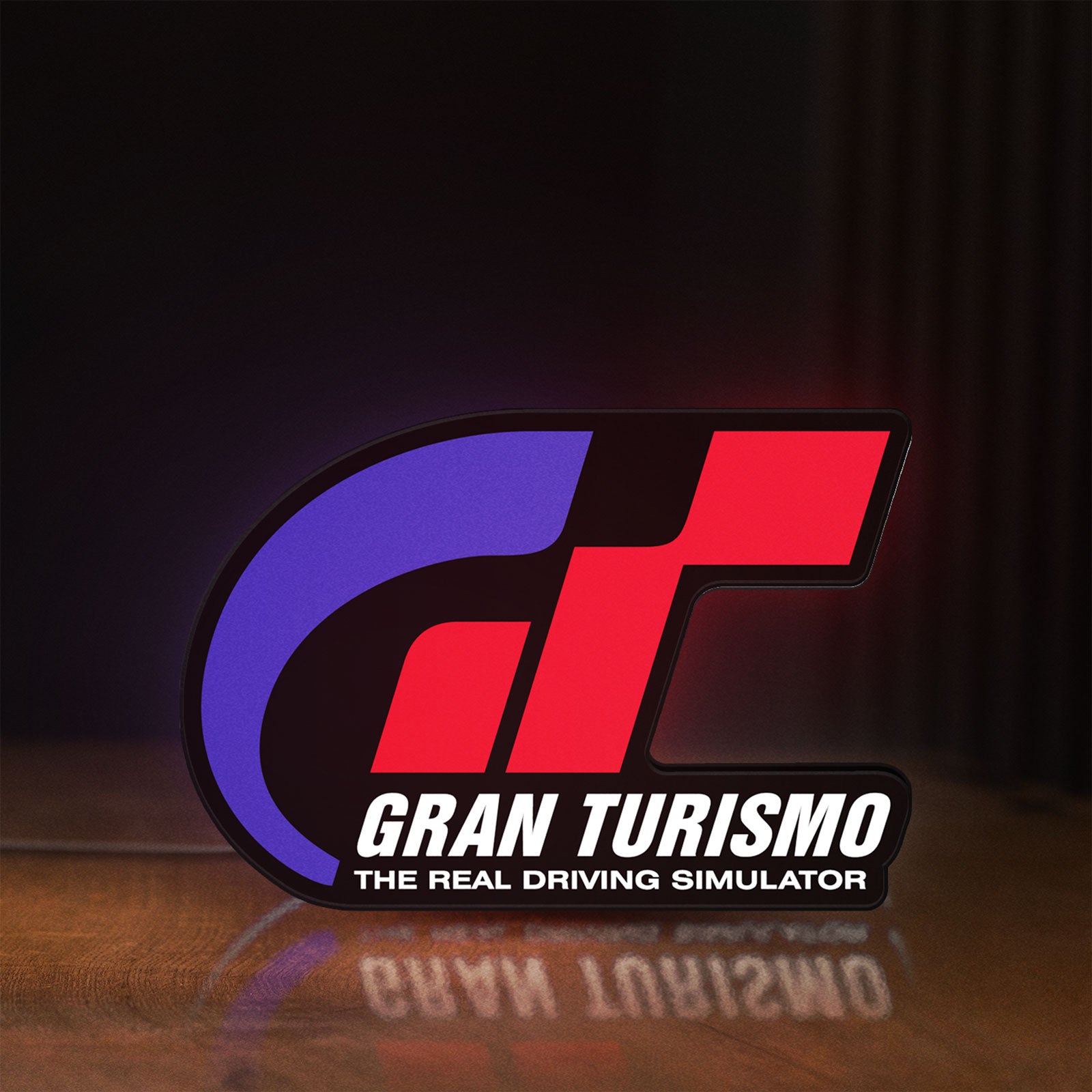 Front view of Gran Turismo LED lightbox sign glowing on a wooden desk