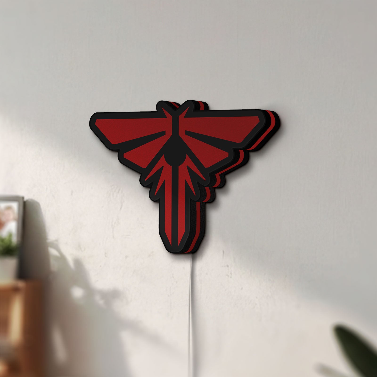 Unlit The Last of Us Firefly Logo LED lightbox mounted on a wall in daylight