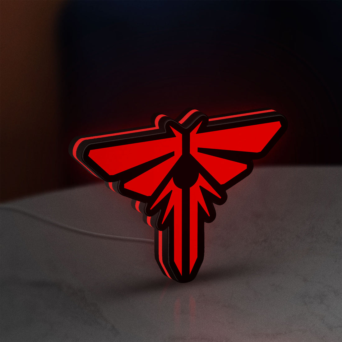 The Last of Us Firefly Logo LED lightbox hanging on a wall with red glow