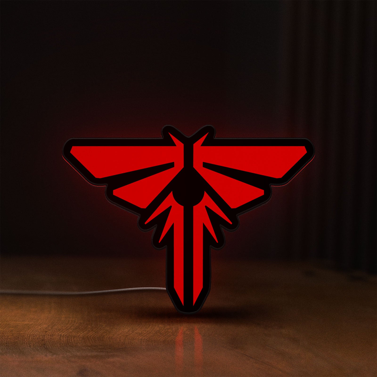 Front view of The Last of Us Firefly Logo LED lightbox sign glowing on a wooden desk