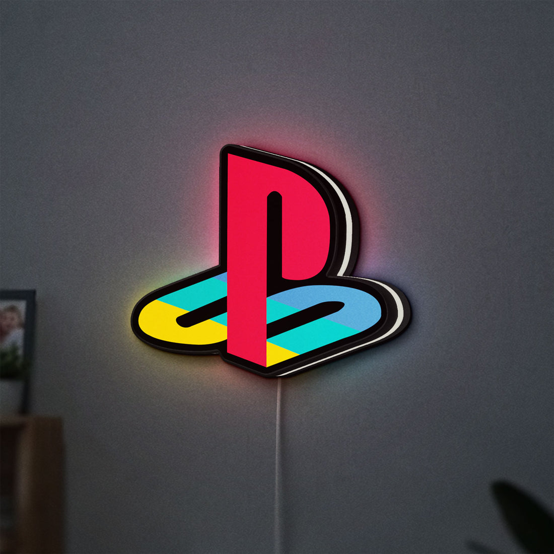 Playstation LED lightbox hanging on a wall with white glow