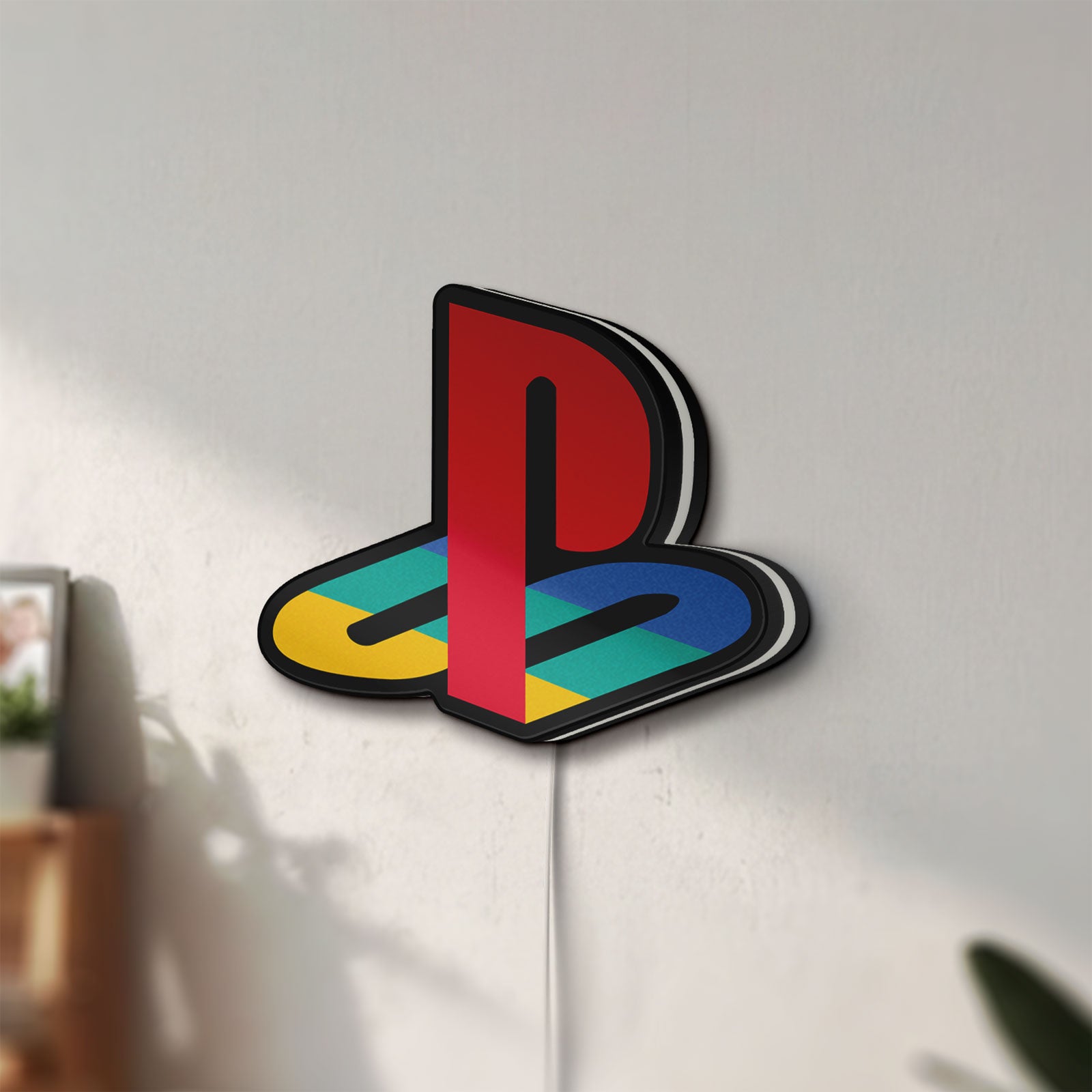 Unlit Playstation LED lightbox mounted on a wall in daylight