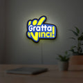 Gratta e Vinci LED lightbox hanging on a room wall with soft yellow light