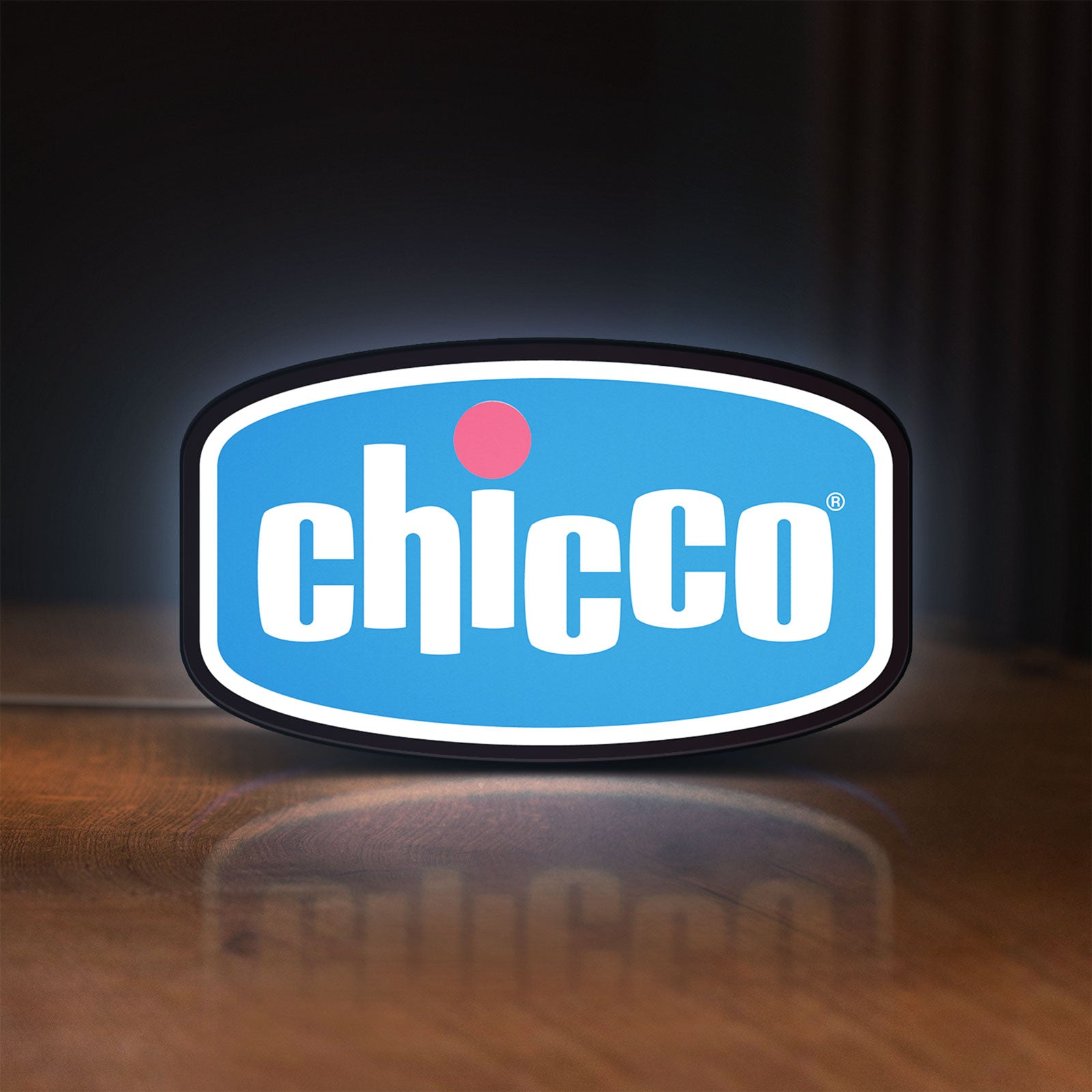Front view of Chicco LED lightbox sign glowing on a wooden desk