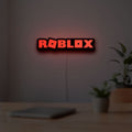 Roblox LED lightbox hanging on a room wall with soft red light