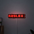 Roblox LED lightbox hanging on a wall with red glow