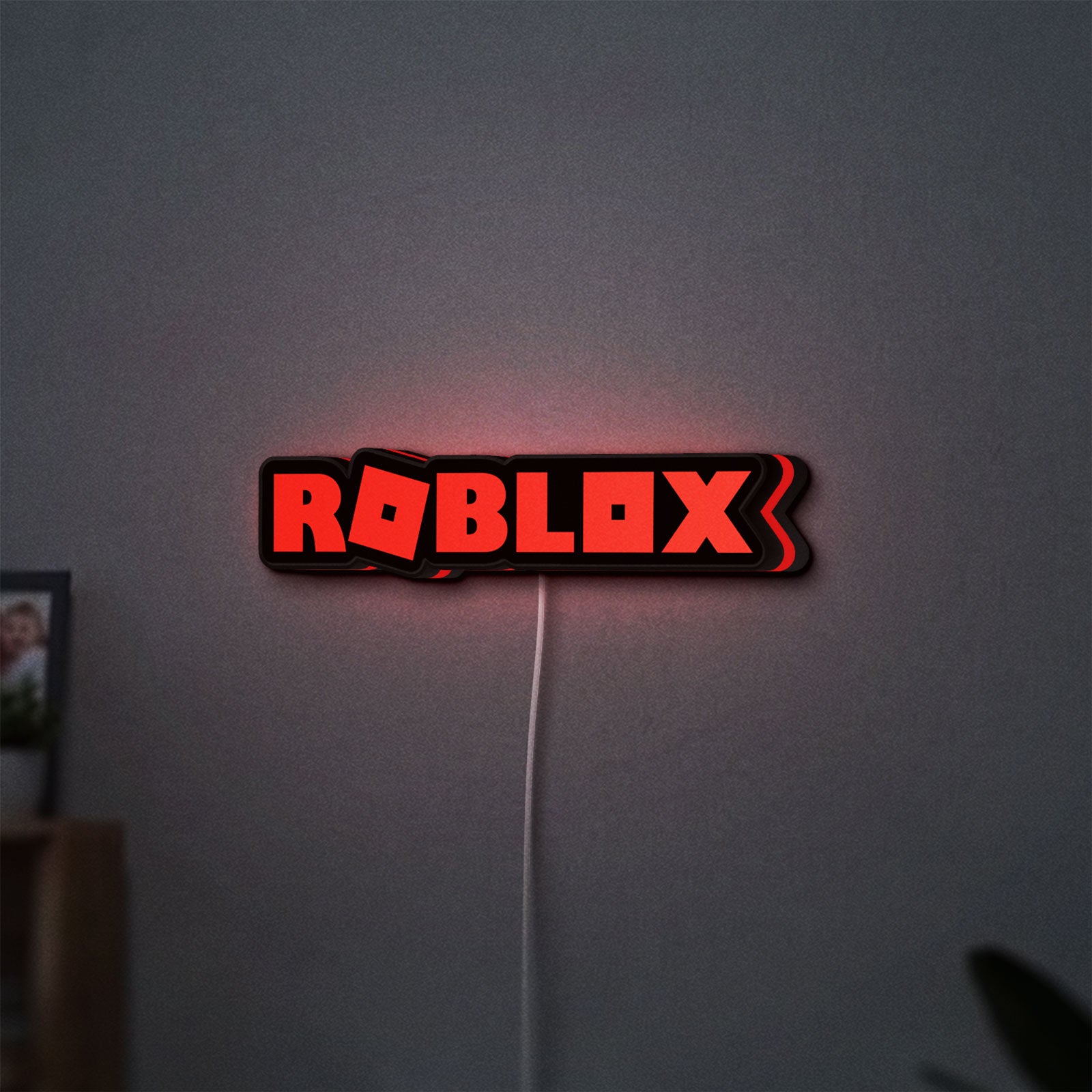Roblox LED lightbox hanging on a wall with red glow