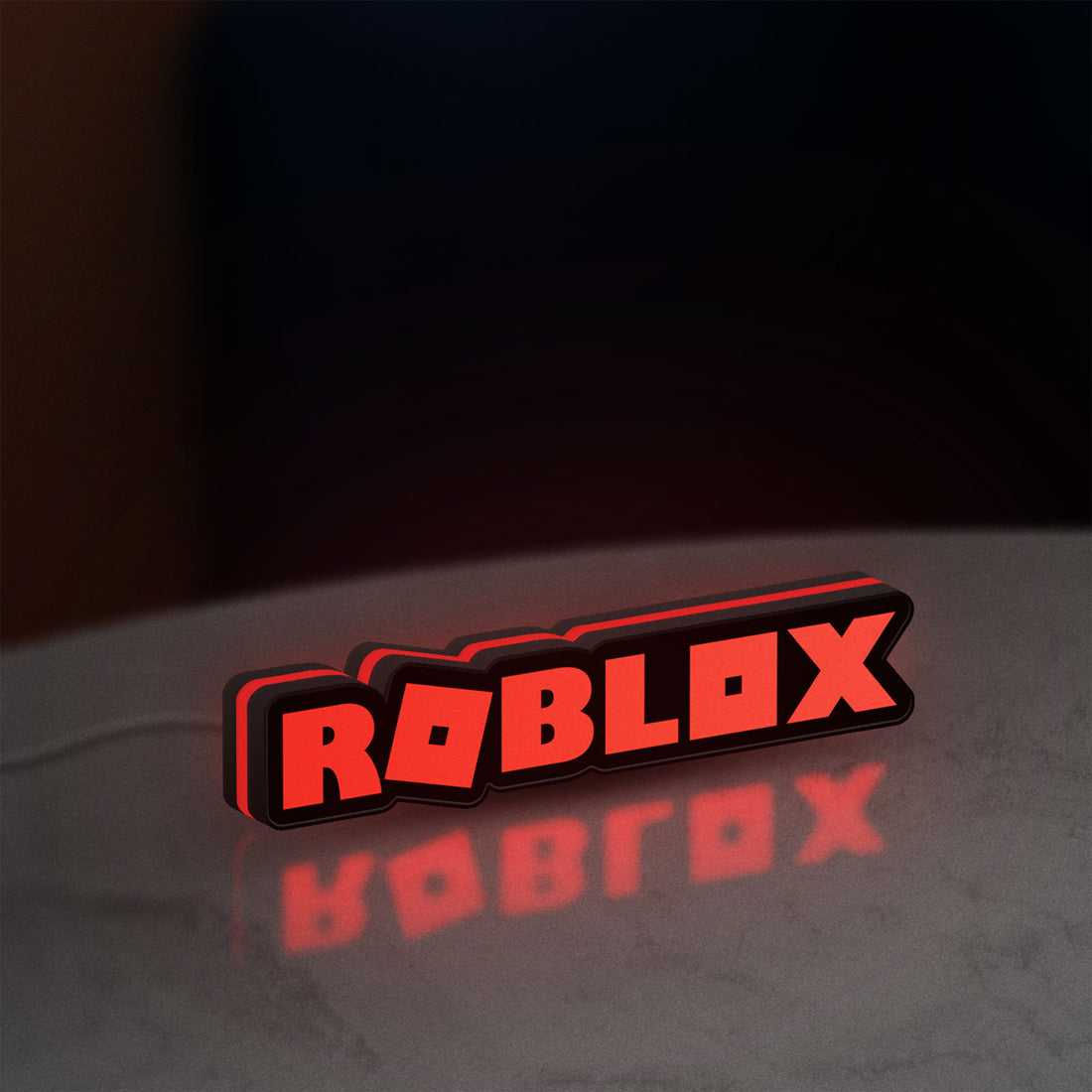 Roblox LED lightbox hanging on a wall with red glow