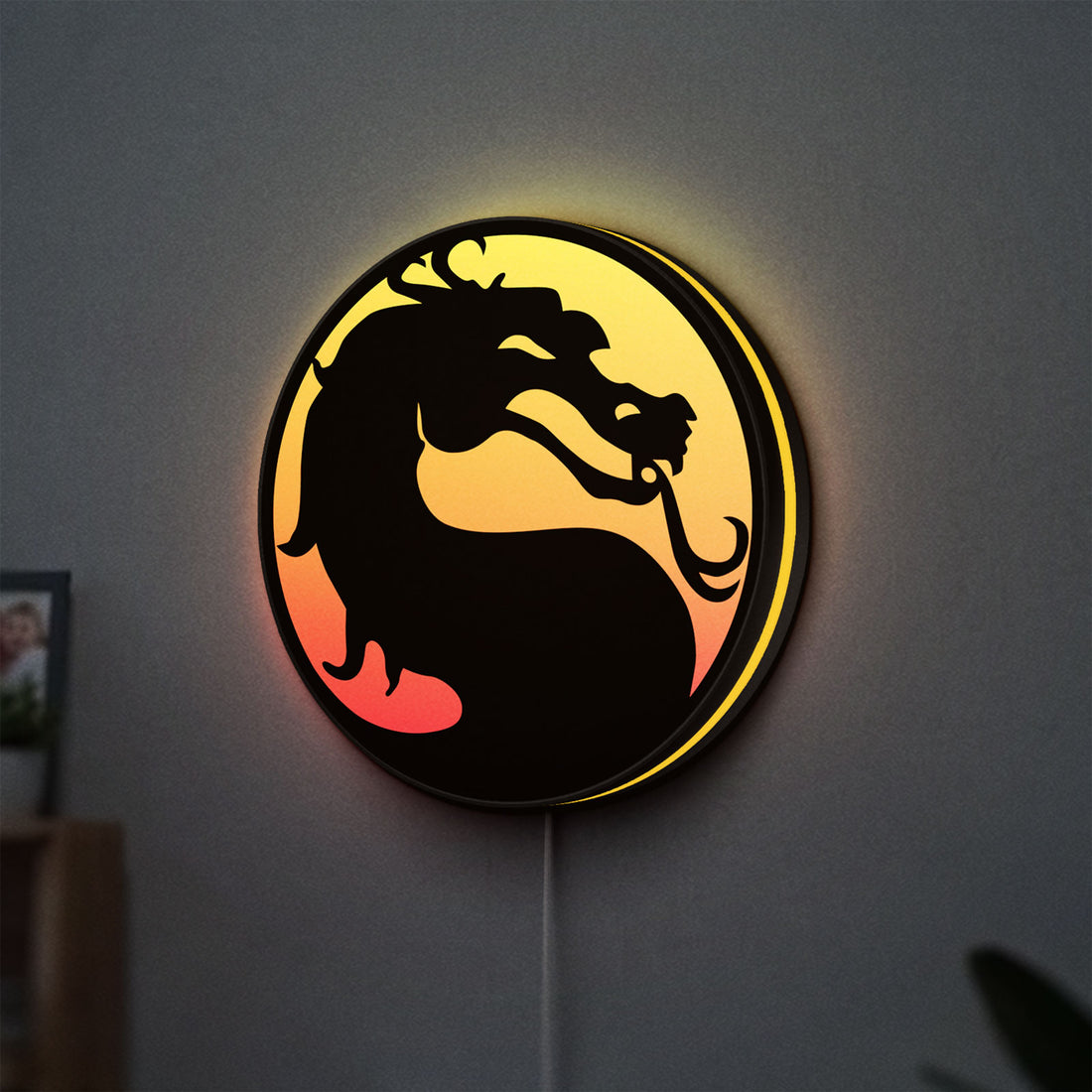 Mortal Kombat LED lightbox hanging on a wall with yellow glow