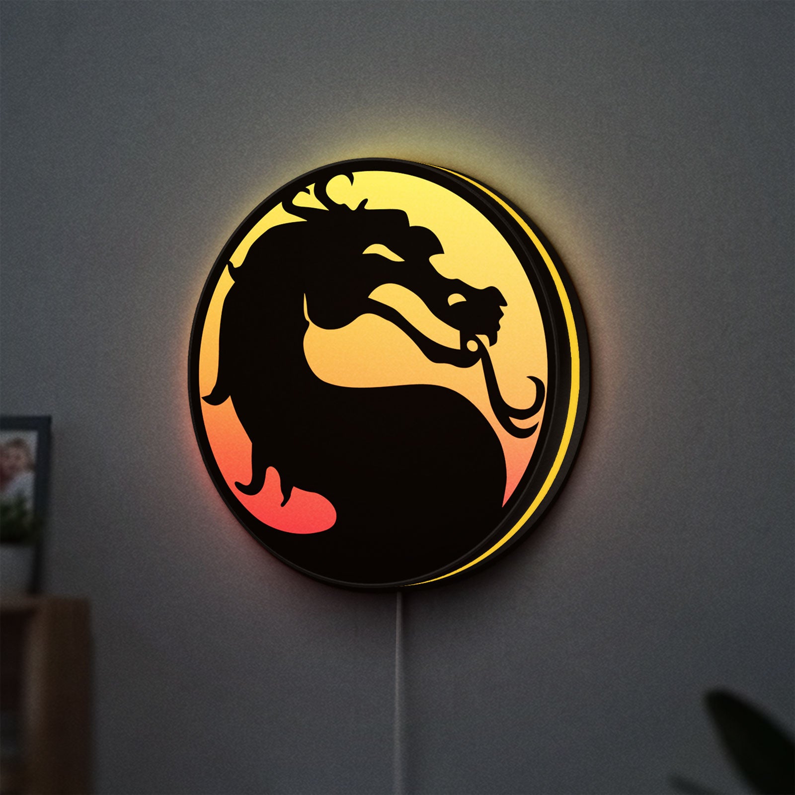Mortal Kombat LED lightbox hanging on a wall with yellow glow