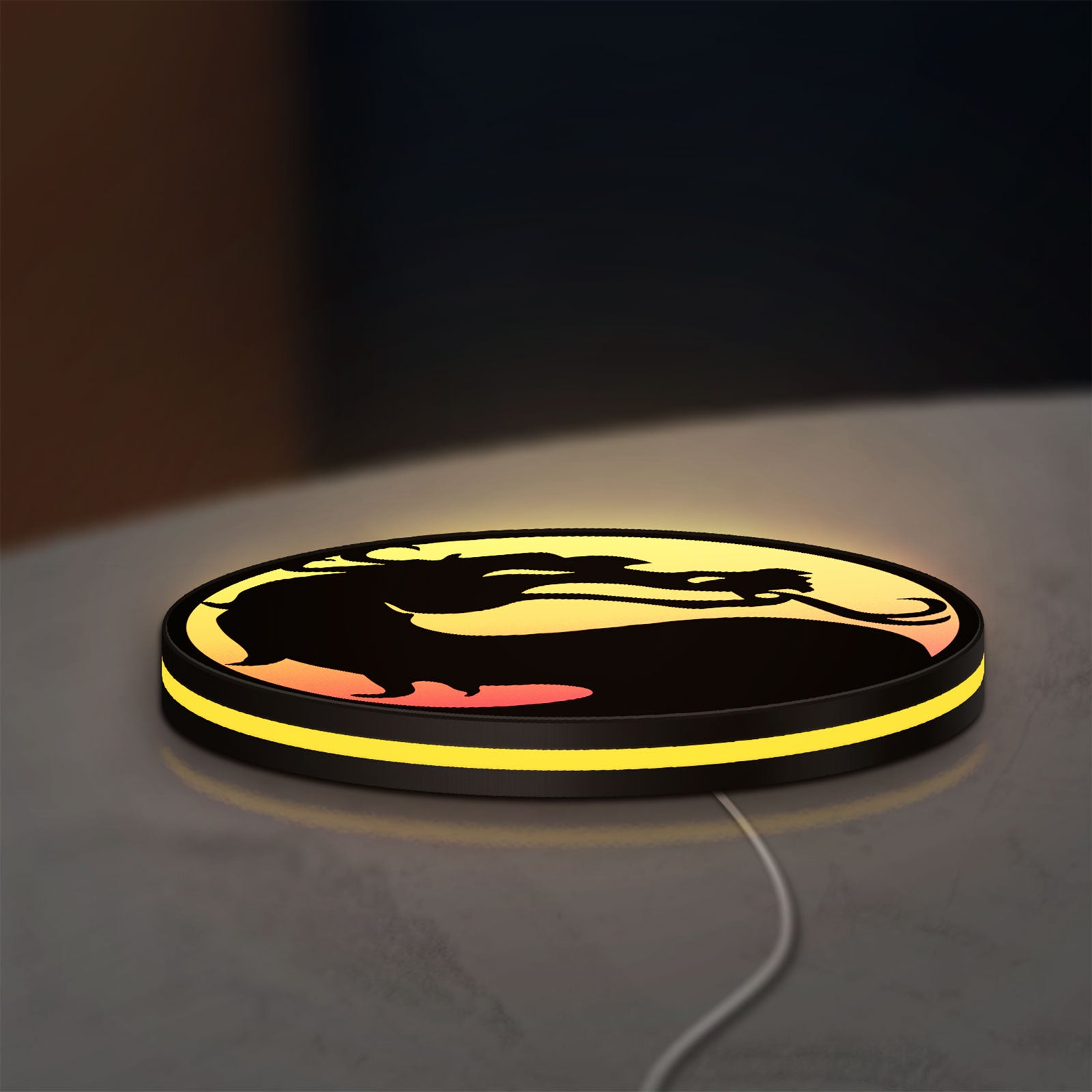 Mortal Kombat LED lightbox lying flat on a desk with yellow glow
