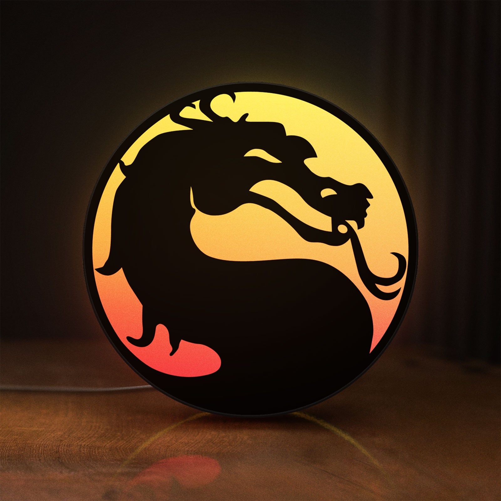 Front view of Mortal Kombat LED lightbox sign glowing on a wooden desk