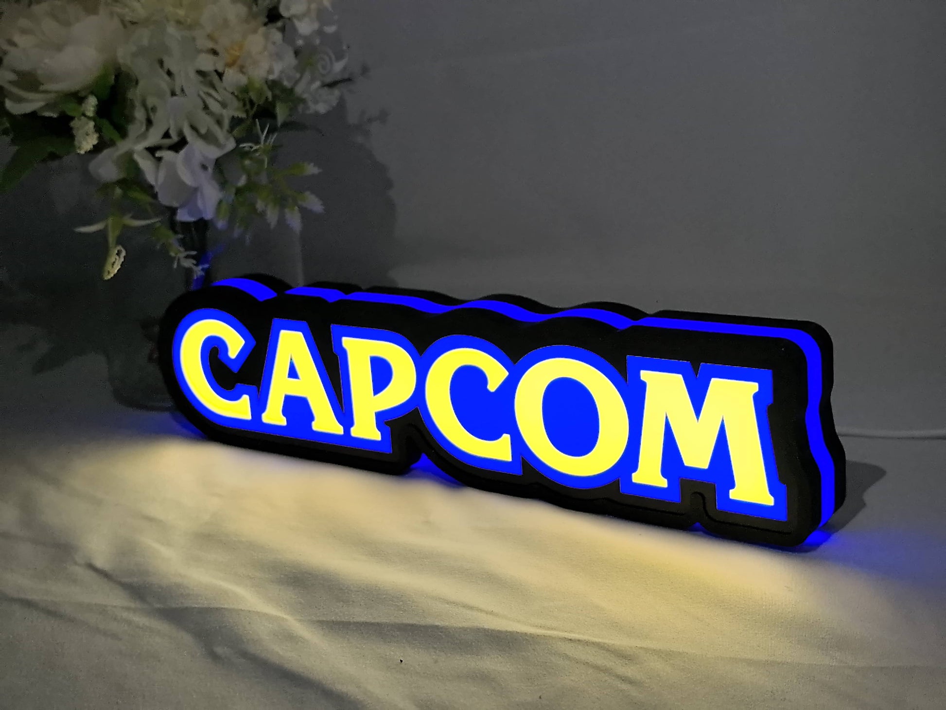 Illuminated angled view standing of Capcom Illuminated Sign in 30cm, unique wall art for desk and room decor