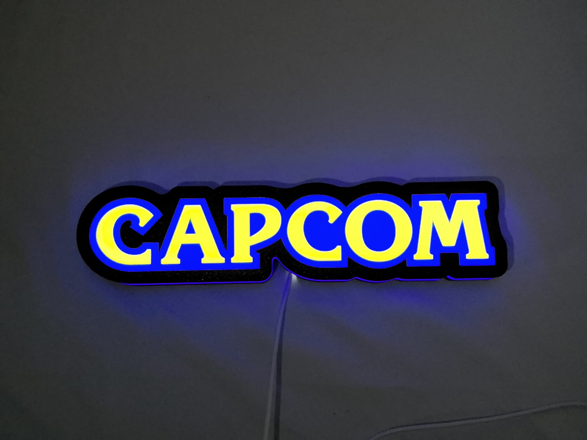 30cm Capcom Glowing Wall Art - Illuminated flat lay front view, unique wall art for desk and room decor