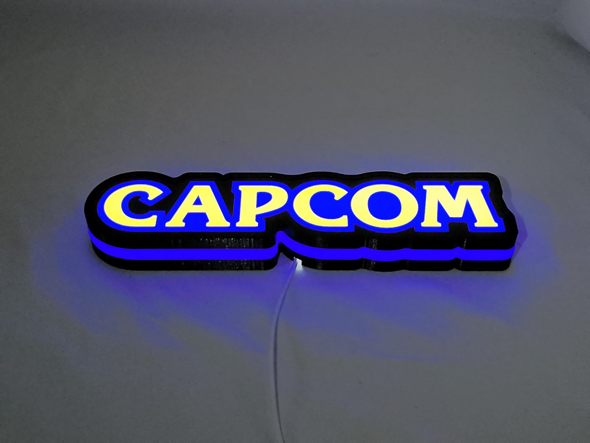 Capcom LED Light Box (30cm) - Illuminated flat lay angled view, unique wall art for desk and room decor