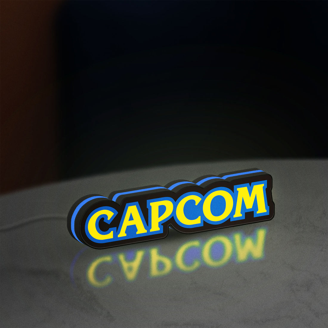 Capcom LED lightbox hanging on a wall with blue glow