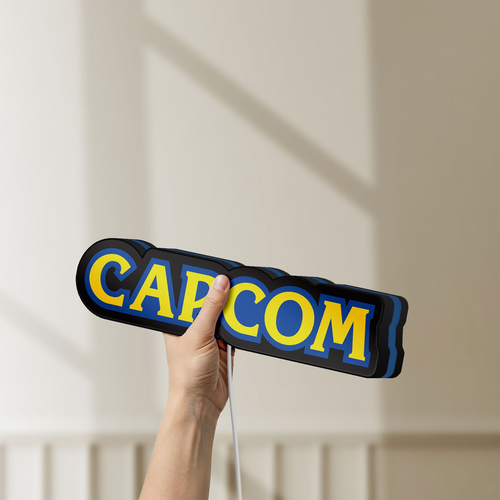 Unlit Capcom LED lightbox held by hand to show size and details