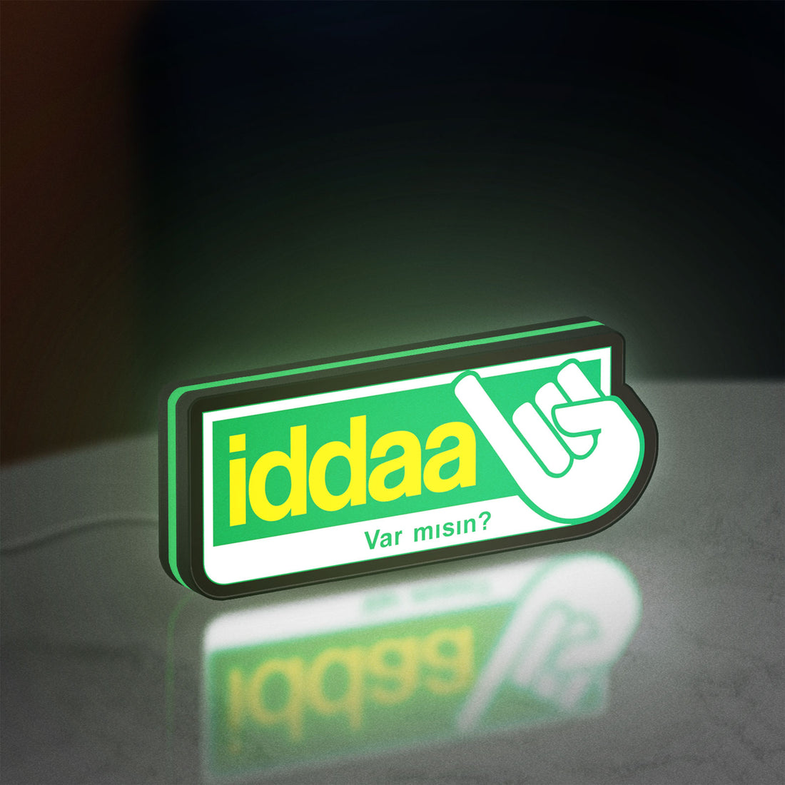 Iddaa LED lightbox hanging on a wall with green glow