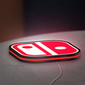 Nintendo Switch LED lightbox lying flat on a desk with red glow