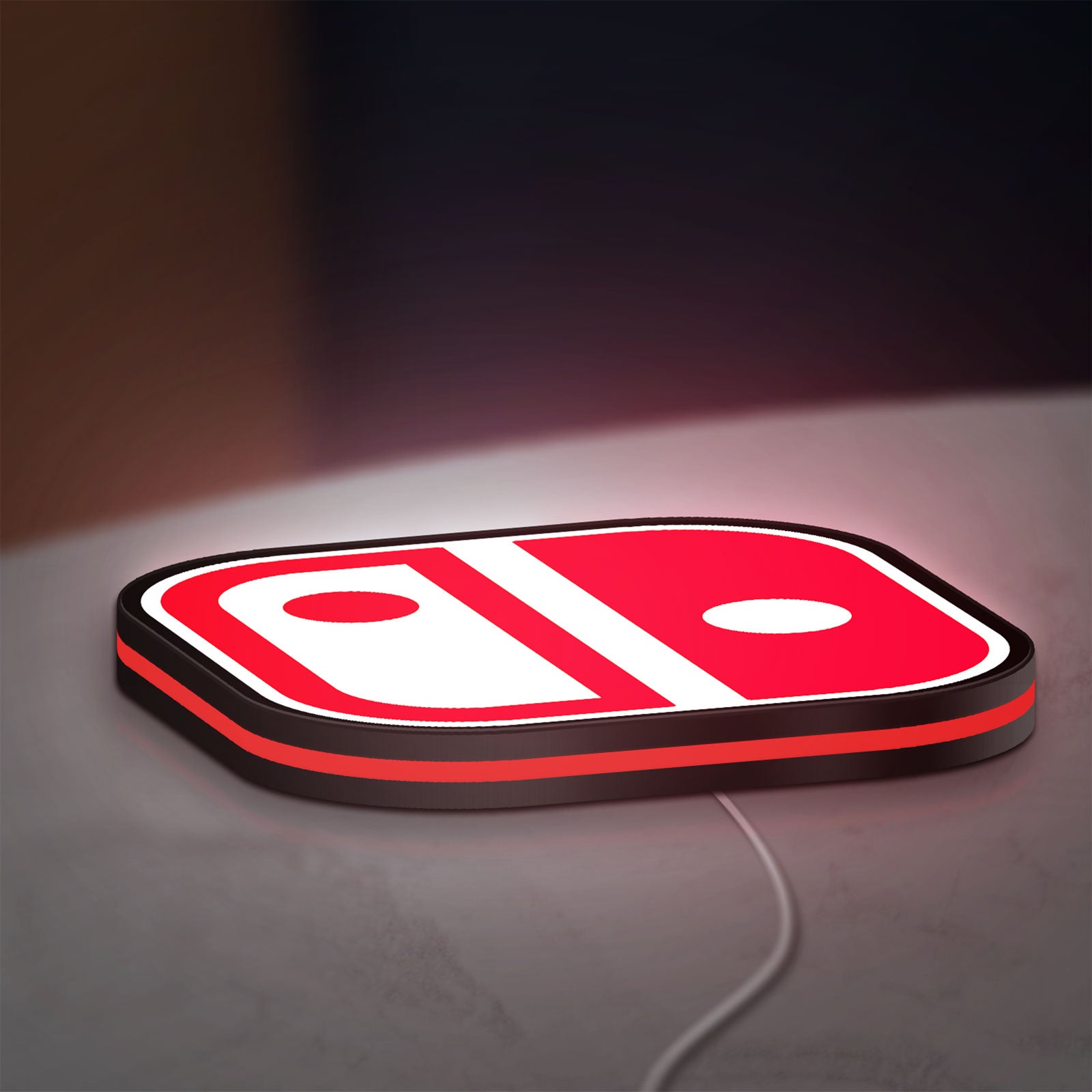 Nintendo Switch LED lightbox lying flat on a desk with red glow