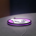 Club Misterio LED lightbox lying flat on a desk with purple glow