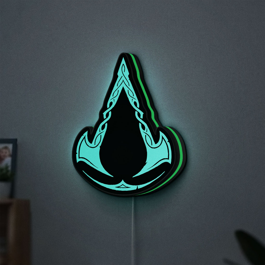 Assassins Creed Valhalla LED lightbox hanging on a wall with green glow