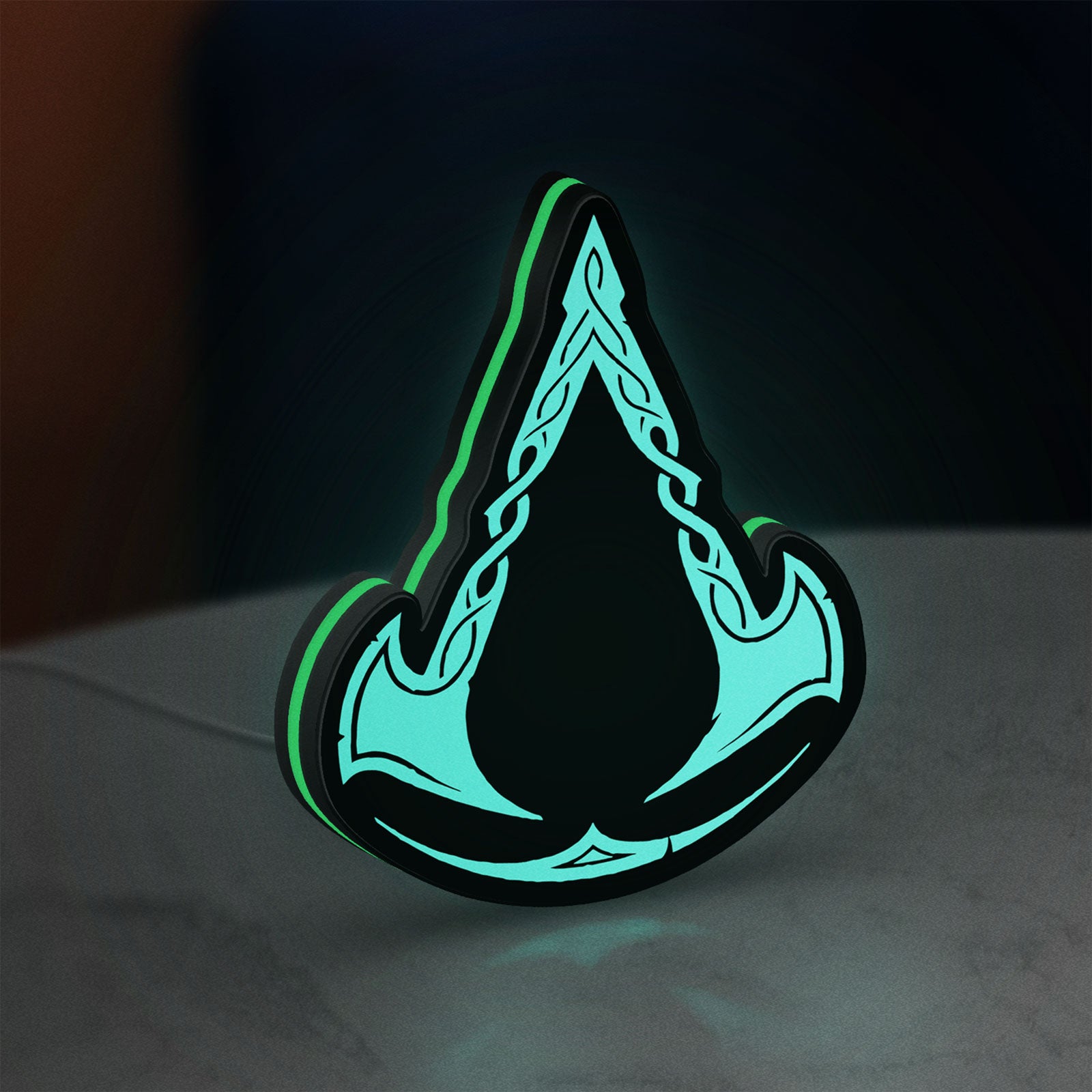 Assassins Creed Valhalla LED lightbox standing on a desk from an angled side view with green glow