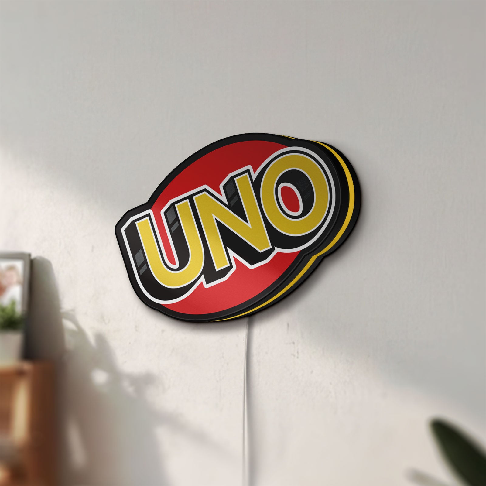 Unlit UNO Wild Draw Four LED lightbox mounted on a wall in daylight
