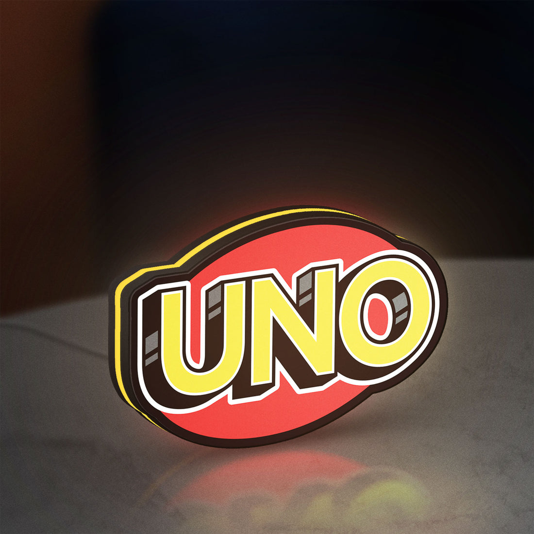 UNO Wild Draw Four LED lightbox hanging on a wall with yellow glow