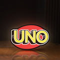 Front view of UNO Wild Draw Four LED lightbox sign glowing on a wooden desk