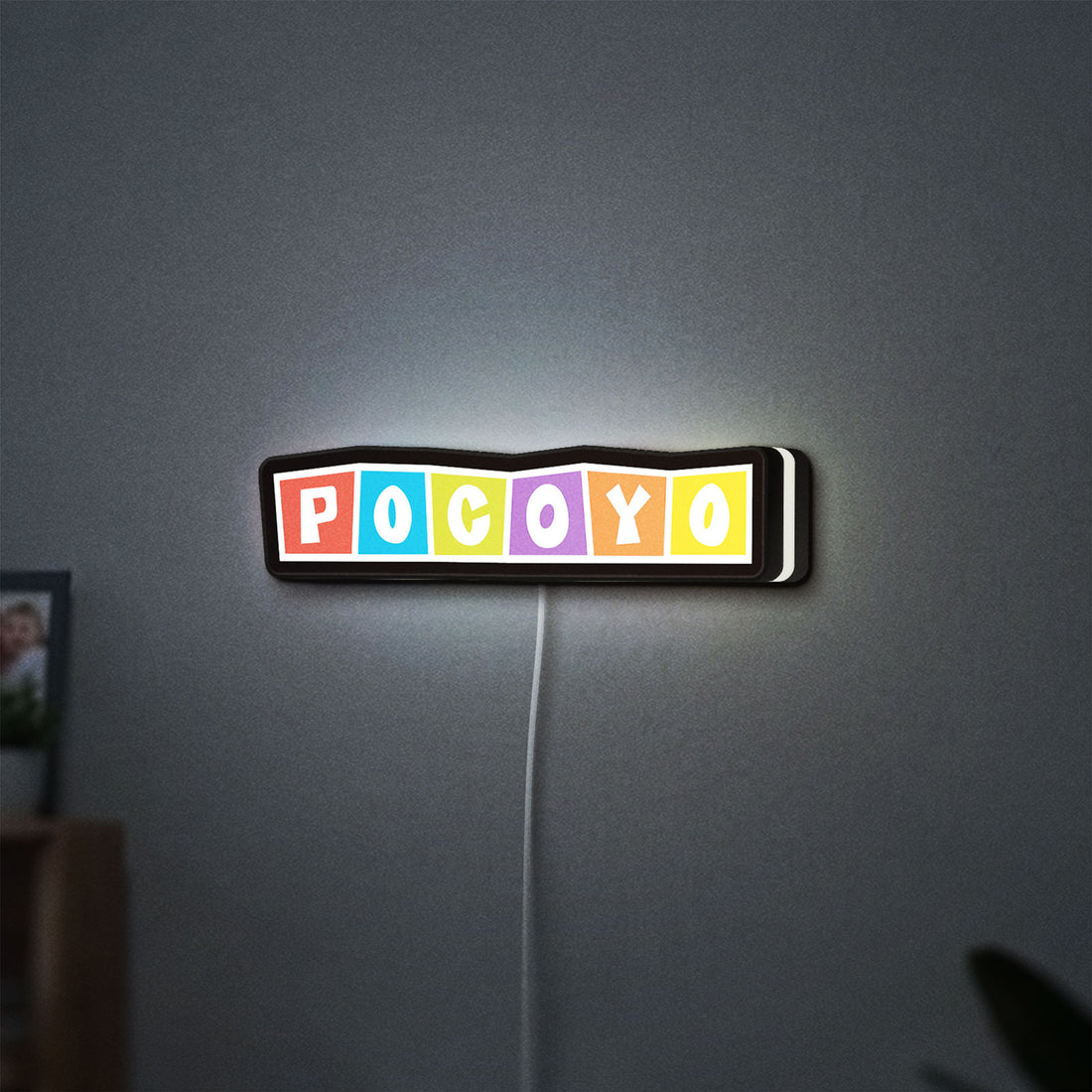 Pocoyo LED lightbox hanging on a wall with white glow
