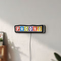 Unlit Pocoyo LED lightbox mounted on a wall in daylight