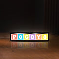 Front view of Pocoyo LED lightbox sign glowing on a wooden desk