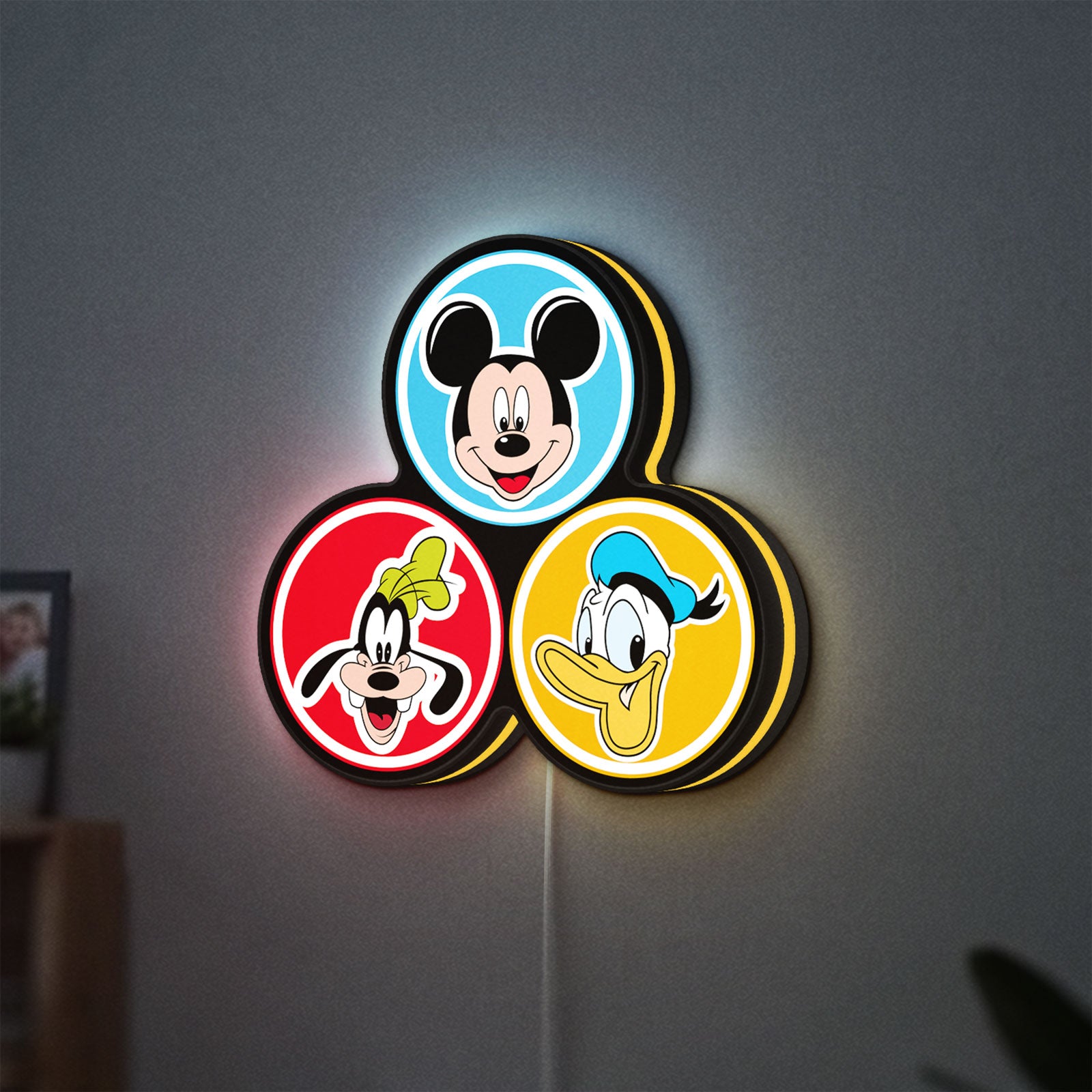 MICKEY DONALD GOOFIE LED lightbox hanging on a wall with yellow glow