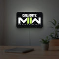 Call of Duty Modern Warfare II LED lightbox hanging on a room wall with soft green light