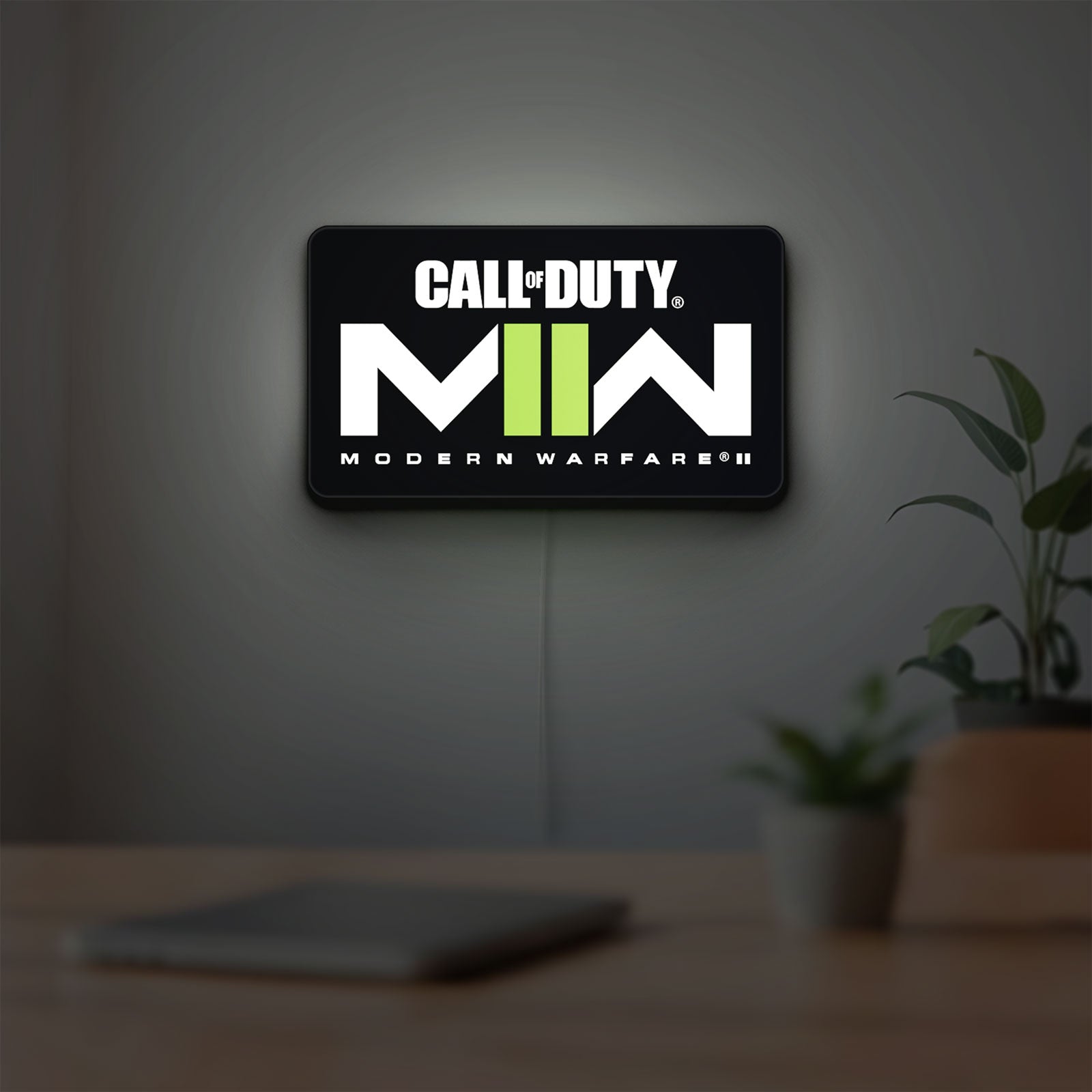 Call of Duty Modern Warfare II LED lightbox hanging on a room wall with soft green light