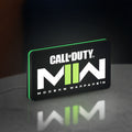 Call of Duty Modern Warfare II LED lightbox standing on a desk from an angled side view with green glow