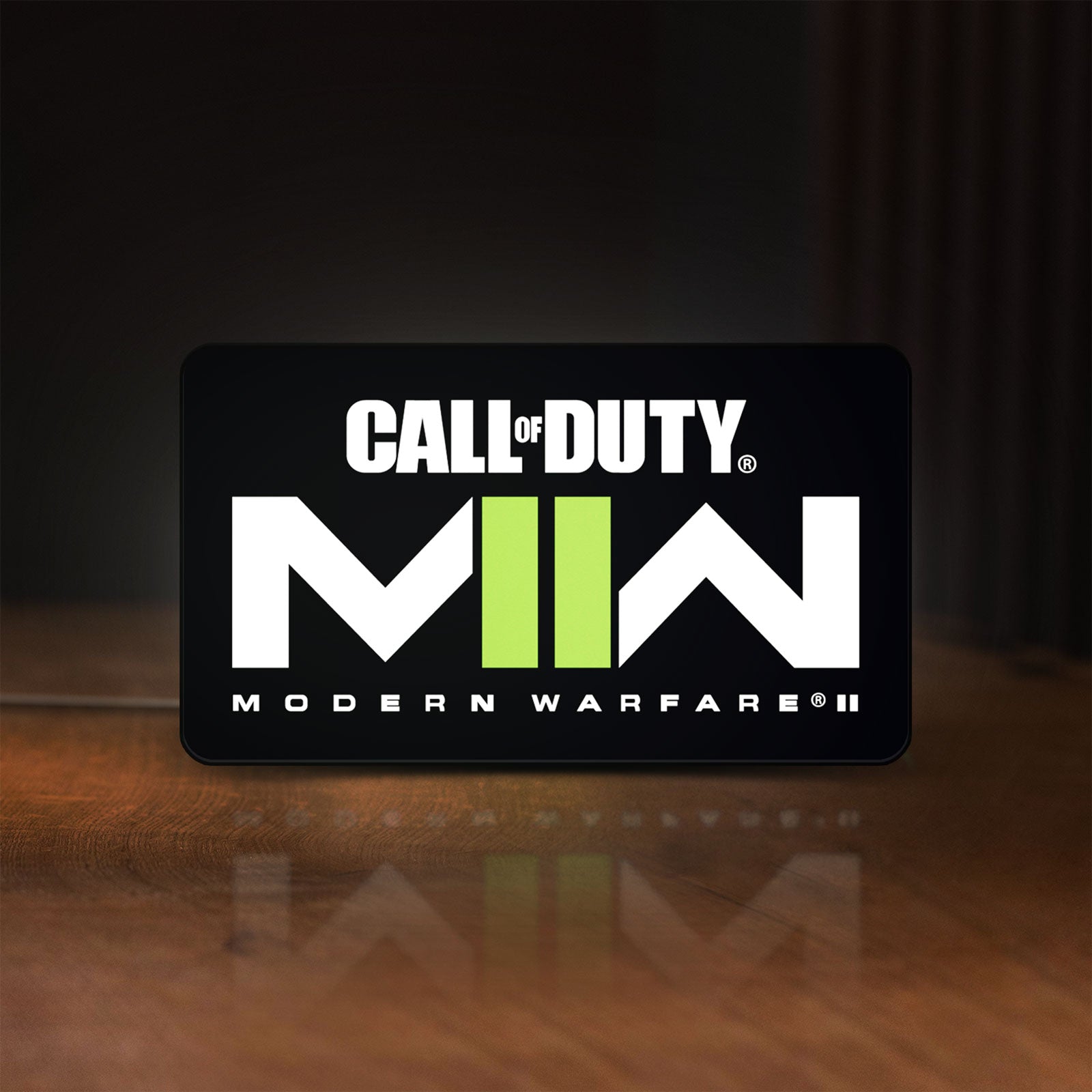 Front view of Call of Duty Modern Warfare II LED lightbox sign glowing on a wooden desk